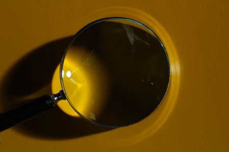 Magnifying glass on a yellow background. Close-up view.の写真素材