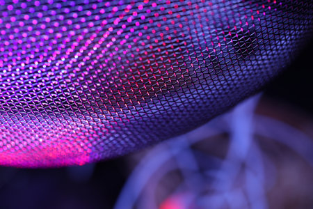 abstract background macro close up of a metal mesh with purple lightの写真素材
