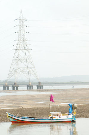 fishing boat on the beach with high voltage pylon in background