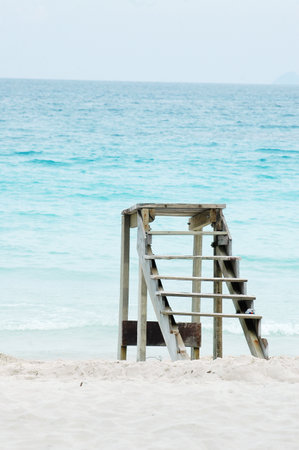 Wooden ladder on the beach with turquoise sea background.の写真素材