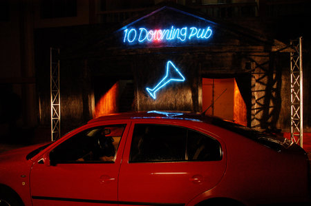 Neon sign of a nightclub on the roof of a red carの写真素材