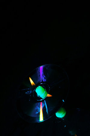 Compact disc with green light on black background. Selective focus.の写真素材