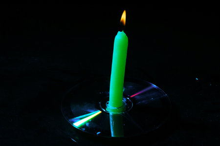 Green candle on a black background, close-up, macro photographyの写真素材