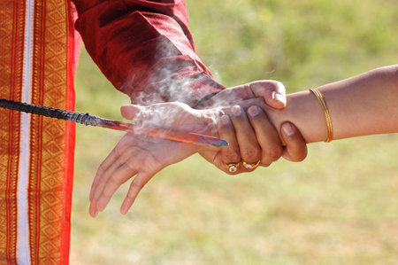 Hands of a man and a woman with incense sticks.の写真素材