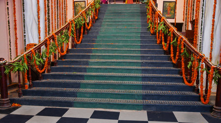 The stairs of the temple decorated with orange garlands of flowers.の写真素材