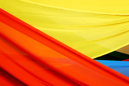 Colourful fabric texture background. Close up of yellow, red and blue clothの写真素材