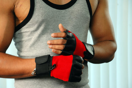 Boxer wearing red gloves, close-up, on light background