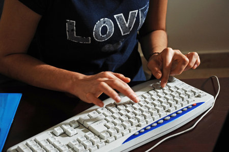 Close-up of female hands typing on computer keyboard with love wordの写真素材