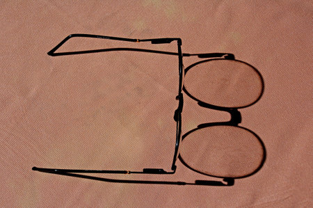 Eyeglasses on a background of pink fabric. View from above.の写真素材