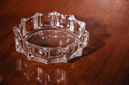 Glass ashtray on a wooden table. Close-up.の写真素材