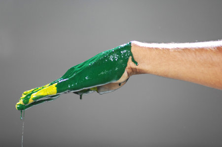 hand with green paint on a gray background, closeup of photoの写真素材