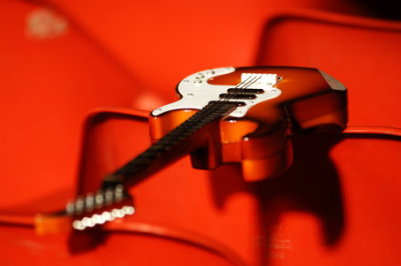 Closeup of an electric guitar on a red background. Musical instruments.
