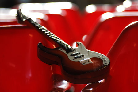 Electric guitar in red seats, closeup of photo with shallow depth of fieldの写真素材