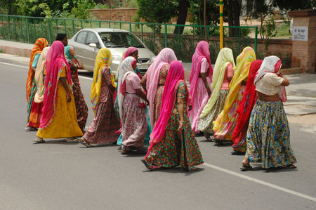 Indian women in colorful saris and scarves walking in the street
