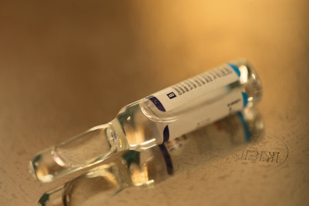 Medical syringe and ampoule on a golden background. Selective focus.の写真素材