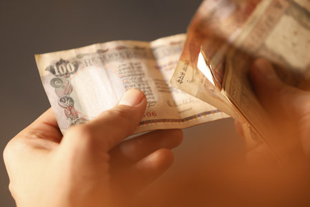 Hand counting money, close-up shot, shallow depth of fieldの写真素材