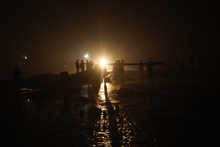 Silhouette of people walking in the sea at night time.の写真素材