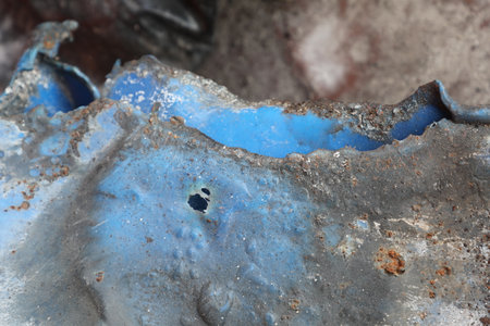 Close-up of a blue piece of metal with holes in it