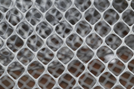 Close up of metal mesh fence background. Selective focus with shallow depth of field.の写真素材
