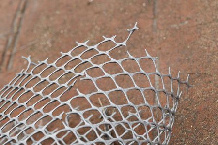 Close up of a wire mesh on a brick floor in the park