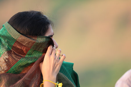 Close up of Indian woman talking on the phone in the field.の写真素材