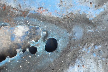 Close-up of blue oil stain on the old rusty metal.