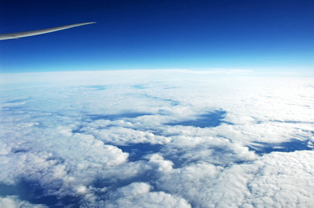 Clouds and blue sky as seen through window of an aircraft.の写真素材