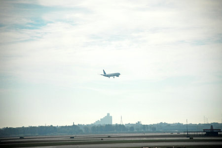 Airplane in the blue sky over the city. Take off.の写真素材