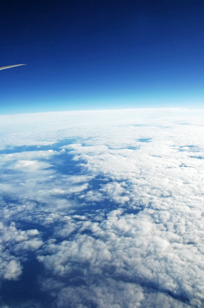 Aerial view of blue sky with white clouds and airplane wing.の写真素材