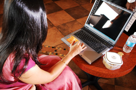 Asian woman using laptop for online shopping in coffee shop, stock photoの写真素材