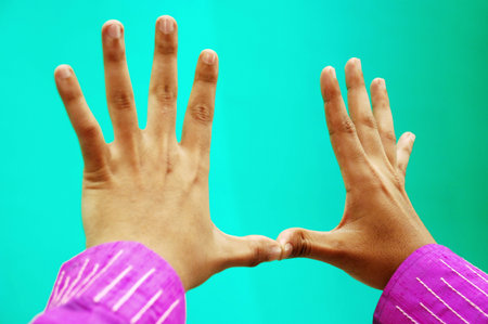 hands of a man and a woman on a turquoise backgroundの写真素材