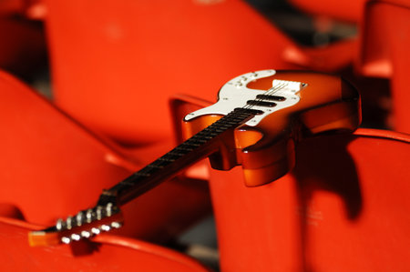 Electric guitar on red seats in the stadium, closeup of photo