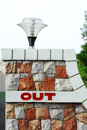 Outlet sign on a brick wall in front of a building.の写真素材