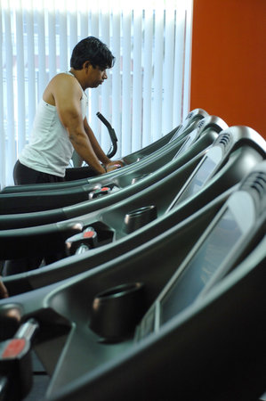 man running on a treadmill in a fitness center, closeup of photoのeditorial素材
