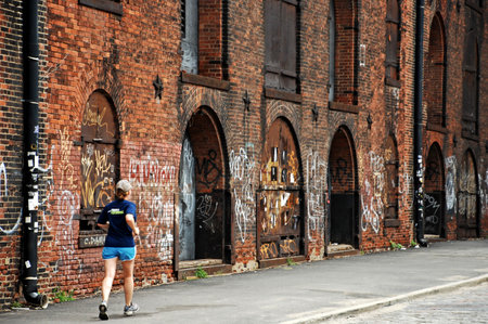 Athletic young woman running in an old brick building.のeditorial素材