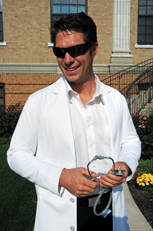 A young man in a white coat and sunglasses holding a stethoscope.のeditorial素材