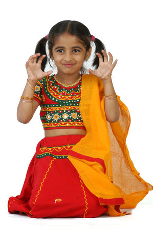An Indian child in traditional dress, isolated on a white background.