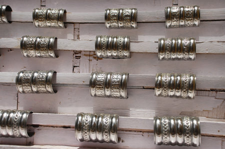 Old silver rings on a white wooden wall, closeup of photo