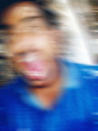 An Indian or asian guy showing his funny facial expression to the camera. Blurred or defocused image.の写真素材