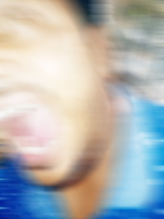 An Indian or asian guy showing his funny facial expression to the camera. Blurred or defocused...