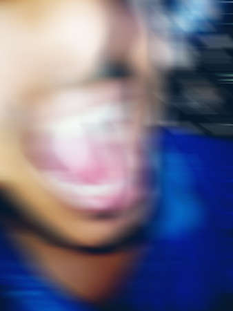An Indian or asian guy showing his funny facial expression to the camera. Blurred or defocused image.の写真素材