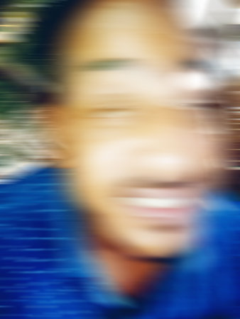 An Indian or asian young man showing his funny facial expression to the camera. Defocused or blurred image.の写真素材