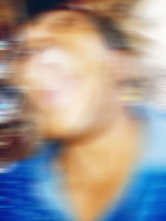 An Indian or asian guy showing his funny facial expression to the camera. Blurred or defocused image.の写真素材