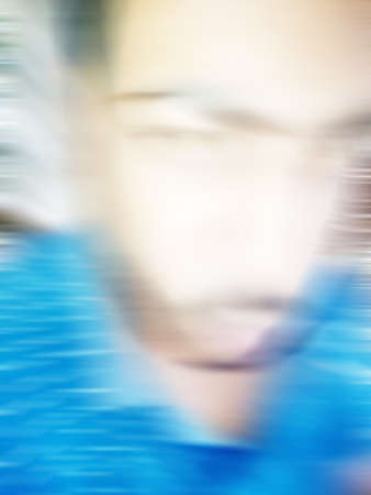 An Indian or asian guy showing his funny facial expression to the camera. Blurred or defocused image.の写真素材