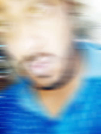 An Indian or asian guy showing his funny facial expression to the camera. Blurred or defocused image.の写真素材