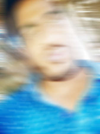An Indian or asian guy showing his funny facial expression to the camera. Blurred or defocused image.の写真素材