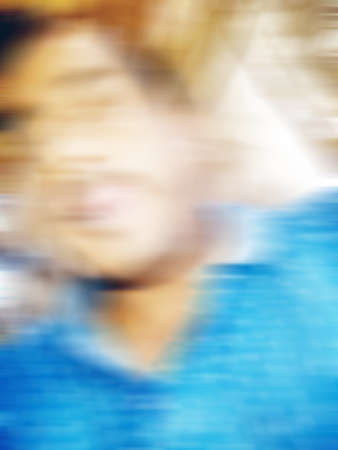 An Indian or asian guy showing his funny facial expression to the camera. Blurred or defocused image.の写真素材