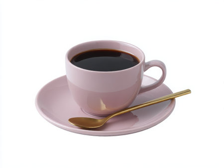 A pink cup filled with dark coffee sits on a matching saucer. A golden spoon rests beside it. The image is clean, simple, and shot on a bright, neutral setting, highlighting the drink.の素材