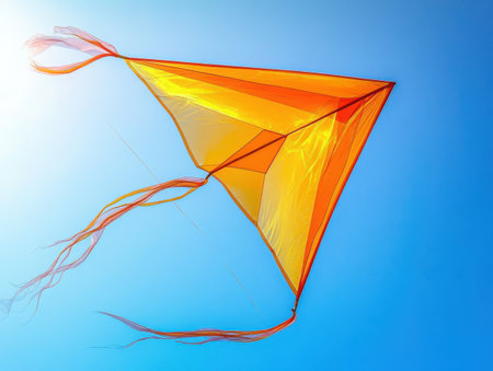 Colorful geometric kite, triangular shape, vibrant orange and yellow hues, translucent fabric, streamers, flying in the sky, clean background, minimalist design, playful summer activity, wind-powered toy, outdoor recreation, crisp edges, lightweight construction, aerial photography, dynamic composition, clear blue sky implied -の素材