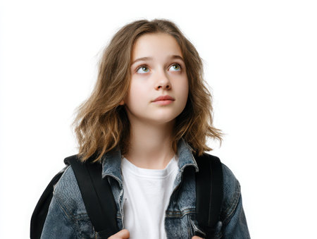 A young girl with a backpack looks up thoughtfully. She wears a denim jacket and a white shirt. The image has a clean, simple aesthetic, ideal for educational or lifestyle concepts.の素材